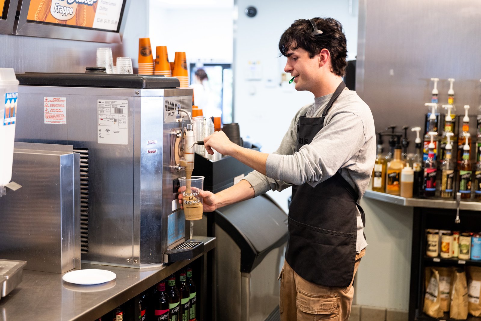 coffeeshop employee working at the coffee bar preparing drinks